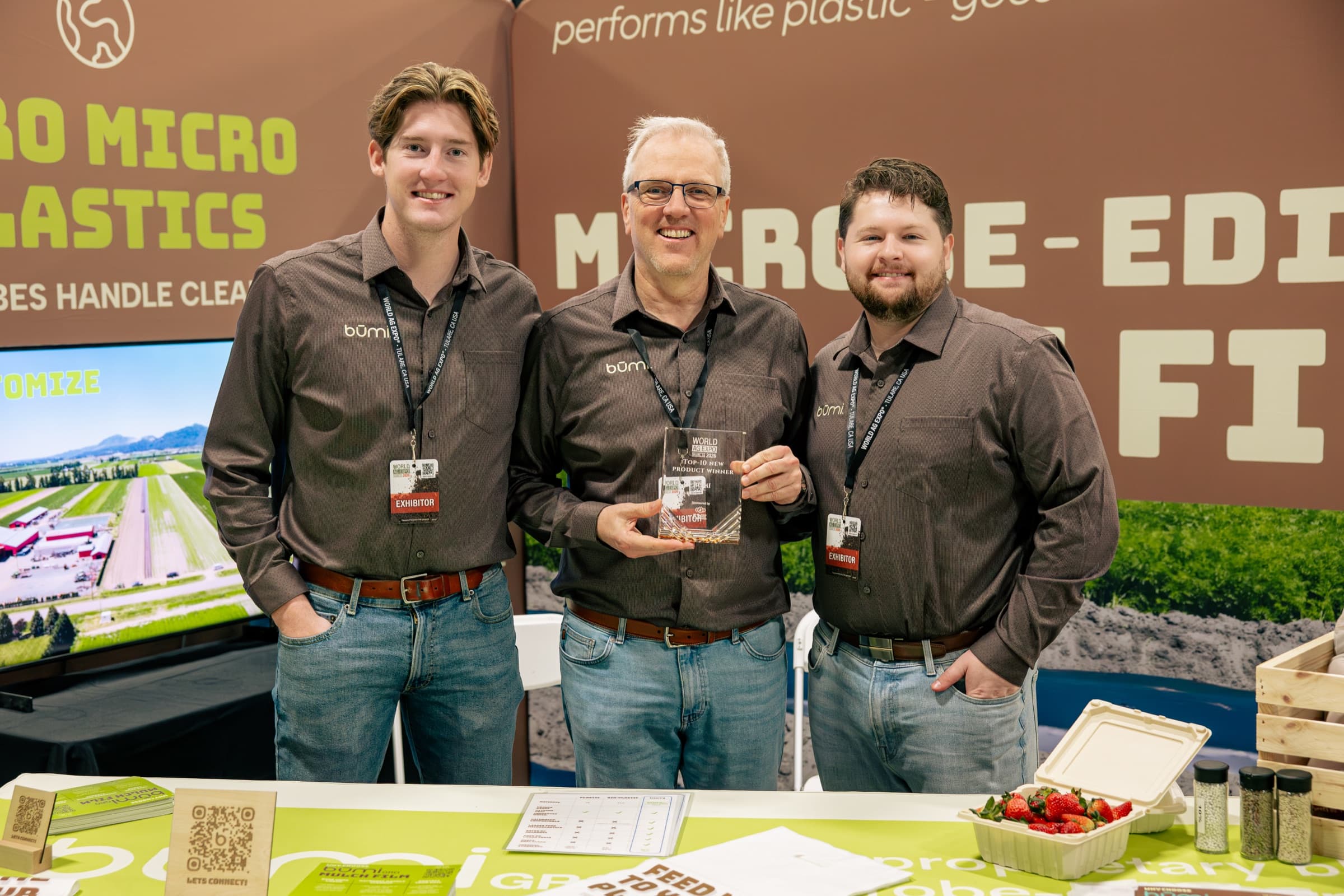 The būmi team holding the Top-10 New Product award trophy at the būmigro biodegradable mulch film booth, 2026 World Ag Expo in Tulare, California